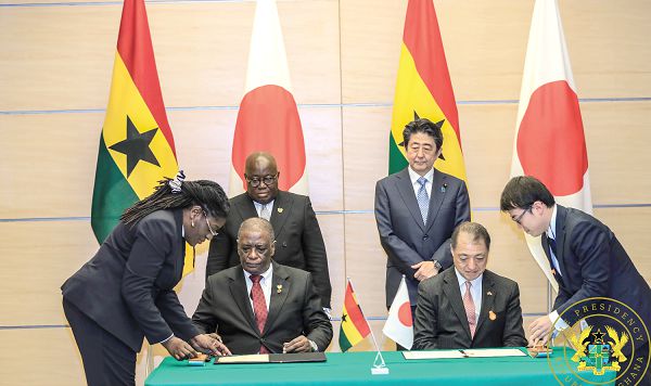 Mr Frank Okyere (seated left), Ghana's Ambassador to Japan,  and Mr Tsutomu Himeno, Japan's Ambassador to Ghana, signing the agreement for the grant of the $57 million. Behind them are President Nana Addo Dankwa Akufo-Addo (left) and Prime Minister Shinzo Abe