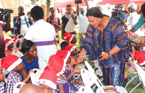  The First Lady, Mrs Rebecca Akufo-Addo (right), sharing gifts to children at the party (inset) the items she presented. Picture: EDNA ADU-SERWAA