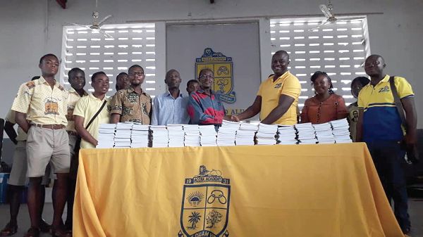 Mr Mohammed Rufai Wuni (3rd right) presenting copies of the books to Rev. William Garr while, some students, staff and old boys look on
