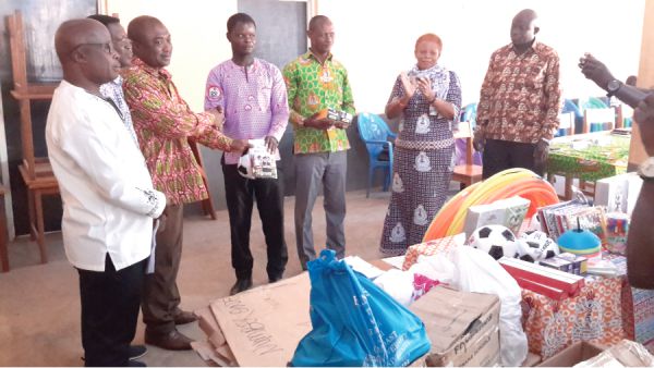 Mr Ernest Asamoah (3rd left) presenting the items to Mr Thomas Musah (4th left) of the Nadowli-Kaleo Directorate of Education, while other officials look on
