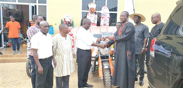 Mr Kwame Tweneboah-Koduah (left) presenting the items to Mr George Oduro, a Deputy Minister of Agriculture in charge of Cocoa