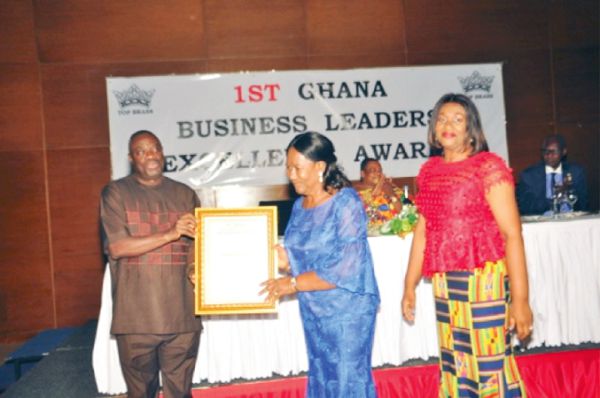 Mrs Comfort Joyce Wireko-Brobby, Executive Chief Executive Officer of Bibiani Logging & Lumber Company Limited receiving her Gold Award in the Timber Processing Category from Dr Mohammed Awal, Minister of Business Development