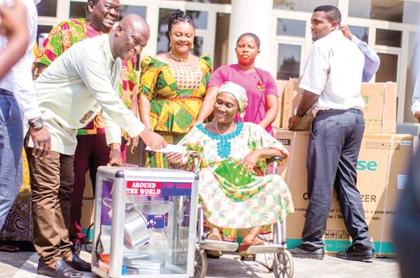  Mr Mohammed Adjei Sowah (left) presenting a popcorn machine and a cash of GH¢200 to Madam Duku (right), one of the beneficiaries.