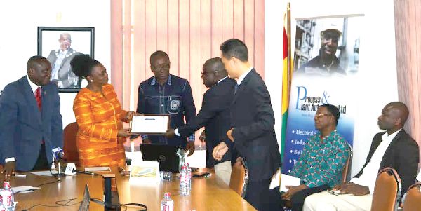 Mr Asmah (2nd right) presenting a certificate of completion of work to an officials of the GhiE