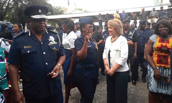A female police officer (3rd left) interacting with Ms Anne-Claire Dufay and other dignitaries at the programme 