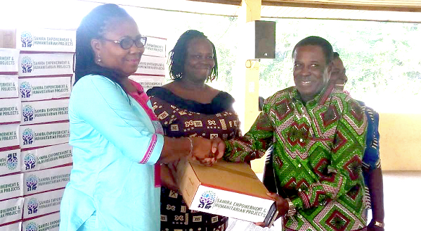 Mrs Jane Sabina Obeng (left) presenting a box of sanitiser to Mr Manfred Barton Oduro, the Headmaster of Mfantsipim School