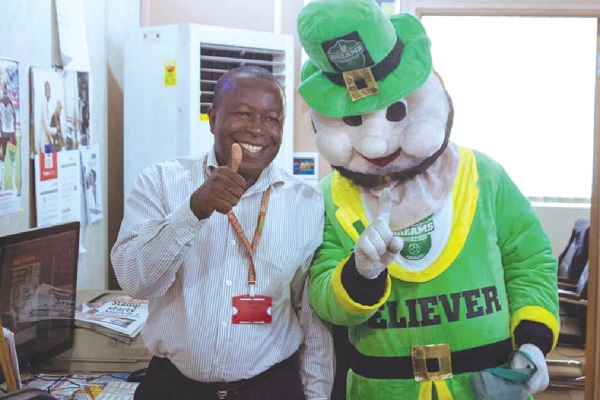  Mr Ebenezer Nyarko, a Lead Designer at  Graphic in a pose with Believer, the mascot.