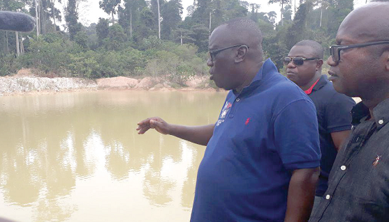 Mr Kwadwo Owusu Afriyie, Chief Executive Officer of the Forestry Commission explaining a point to the media while standing beside one of the trenches. With him is the District Chief Executive of Amansie Central, Mr Asamoah Boateng
