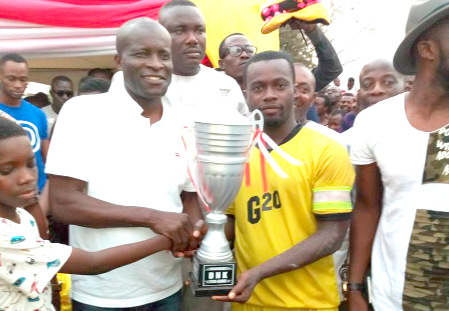 The Member of Parliament (MP) for Tema East, Mr Titus Glover (left) presenting the trophy to  Michael Doku Addo, captain of Site Five