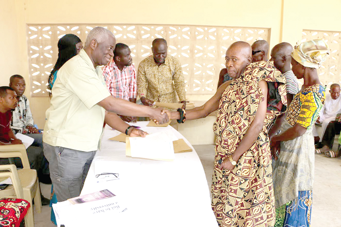 Mr Fred Oware (left), CEO of Bui Power Authority, handing over documents to Nana Kwadwo Wuo II, the chief of Bui