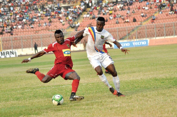 Kotoko’s Frederick Boateng clearing the ball under pressure from Hearts’ Richard Akrofi.