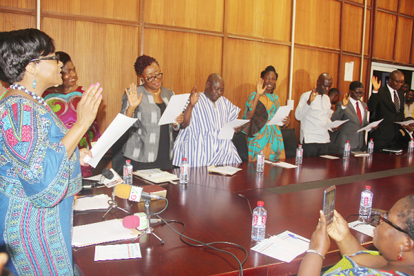  Mrs Otiko Afisah Djaba (left) administering an oath to members of the Technical  Committee