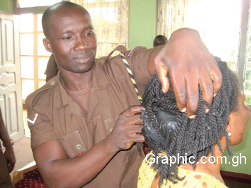 A prison officer retrieving concealed phone from a visitor’s hair
