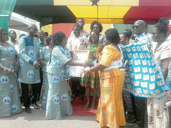  Mrs Margaret Frempong-Kore, (4th left), acting Greater Accra Regional Director of Education, presenting the best head teacher award, SHS category, to Mrs Elizabeth Ama Asare, Headmistress of Tema Senior High School.