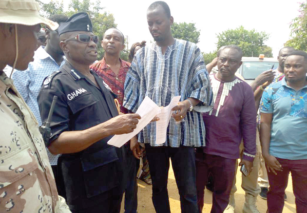   Mr Godwin Amarh (in smock) explaining a point to DCOP Kojo Gyan Kyere