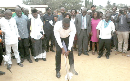 Mr Felix Nii Anang-La (with pick-axe), the MCE for TMA, cutting the sod to indicate the start of the project. Looking on are some officials of the GES and other guests