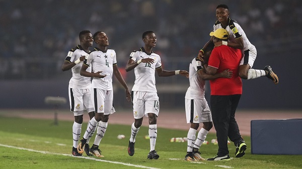 Team Ghana celebrates with their head coach Samuel Fabin after scoring a goal.