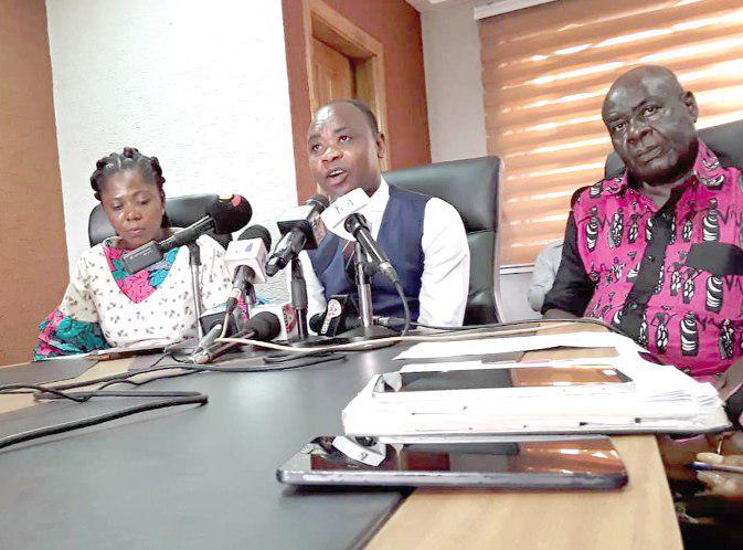 Mr Bright Appiah (middle) addressing the media in Accra. With him are two officials of the coalition