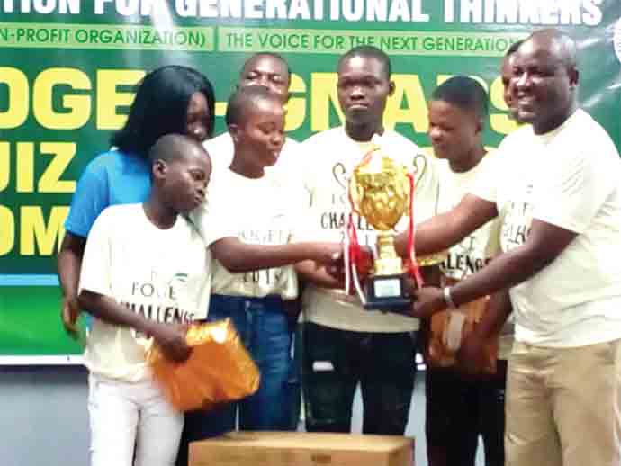 Mr Prosper Dan Afetsi (right) presenting the trophy to contestants of S. Sowah Boye Memorial School who won the 2018 FOGET-GNAPS Quiz and Challenge Competition