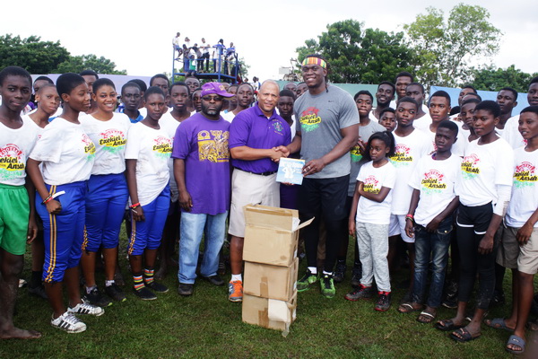 Dr Bryan Cox, Chief Executive Officer of the Spinal Clinic limited presenting the books to Mr Ezekiel Ansah, Founder of the organisation  at a ceremony in Accra.