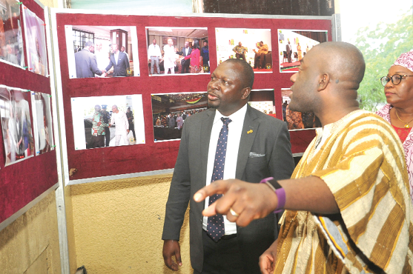 Mr Kojo Oppong Nkrumah conducting Mr John Awuah (left) round an exhibition of photographs of the 2017 summit. With them is Mrs Patricia Dovi-Sampson, Director of Policy at the Ministry of Information. Picture: EBOW HANSON