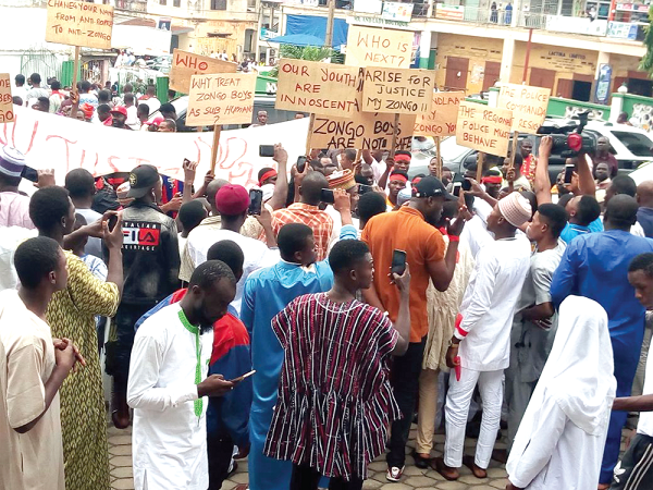 The youth holding placards demonstrating in front of the Central Mosque in Kumasi