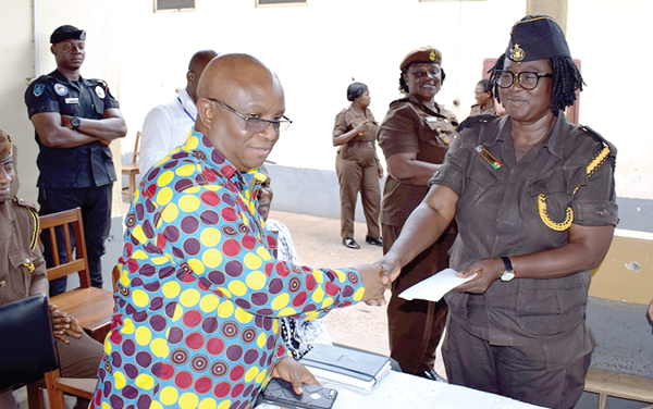The regional minister (left) handing over the cash to the Officer incharge of the Ho Female Prisons, Supt Dankwa