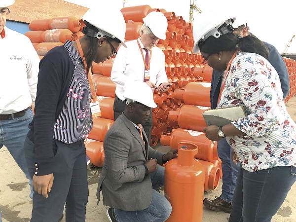 Mr Alhassan Tampuli (arrowed), the Chief Executive Officer (CEO) of the National Petroleum Authority (NPA), inspecting a filled cylinder during a recent visit to Bogota, Colombia, with some officials of the NPA