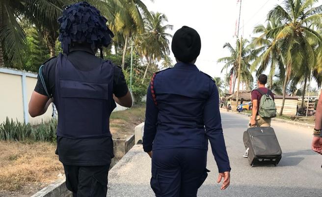 Ghanaian security forces escort 'Yes We Help' volunteers leaving the Winneba residence