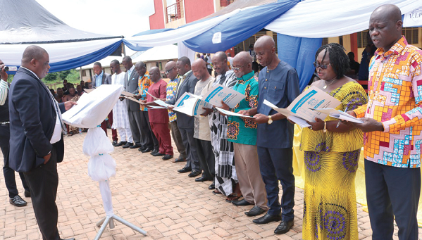 Mr Sam Medjida Nibi (left), the District Magistrate, Nyinahini, administering the oath of office to the newly-constituted Board of Governors of the Adobewora Community Senior High School. Picture: EMMANUEL BAAH