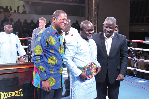 Azumah Nelson, flanked by Peter Zwennes and Lt. General Obed Akwa (right),wears an honorary world title belt presented by the WBC.