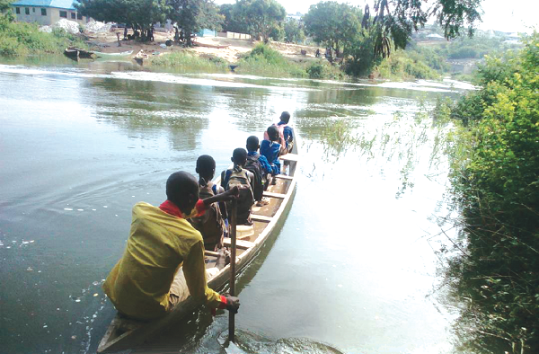 Schoolchildren paying for a canoe ride to cross the Densu River