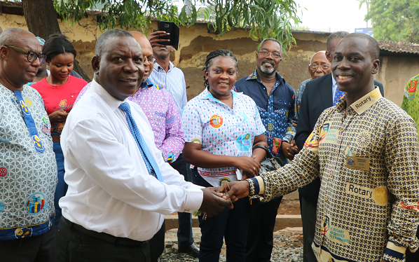 the President the Rotary Club of Accra-West, Mr Emmanuel Quarshie (right) presenting the keys to the facility to Mr Israel Martei, the Kanda Circuit Supervisor 