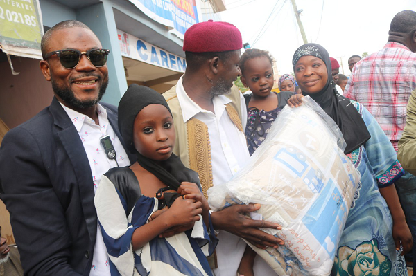 Sheik Mohammed Ridwan Mohammed(in hat) CEO of Alpha Radio, presenting a brand-new beds sheet to one of the beneficiaries, at the forecourt of the radio station at Anhwia-Overseers near Tafo in Kumasi.