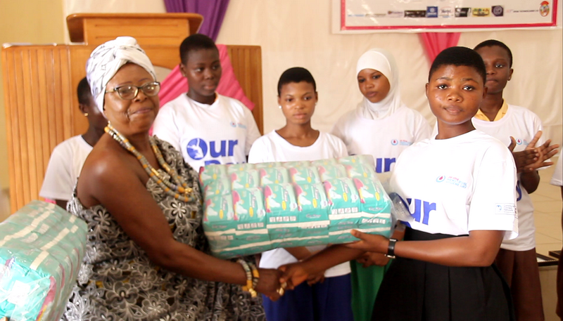 Nana Yaa Daani II Omanhemaa, New  Juaben Traditional Area presenting sanitary pads to some of the  students