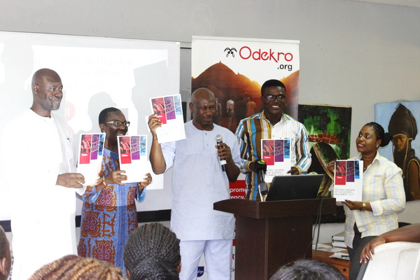 Mr AIbrahhim-Tanko Amidu (middle) with others raise the report to launch it