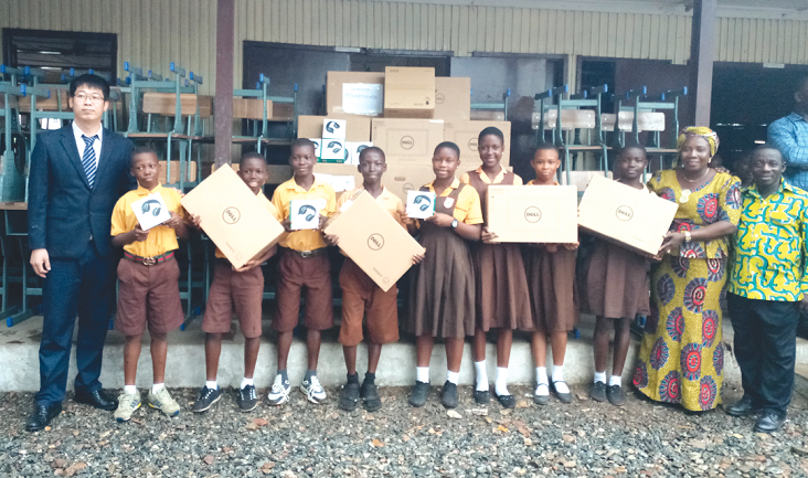  Mr Zhang Xueli (left) after presenting laptops to Mrs Irene Yankson Neequaye (2nd right). With them are some students displaying some of the  laptops
