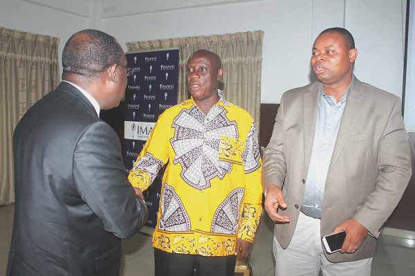  Nana Obiri Boahen (middle) in a handshake with Mr Kofi Bentil (back to camera). Looking on is Mr Franklin Cudjoe. 