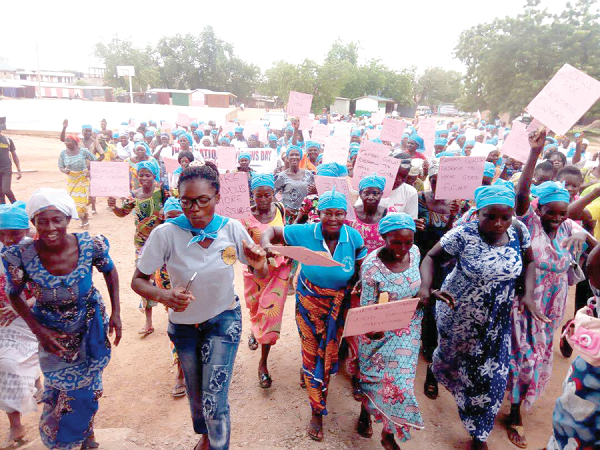 Widows carrying placards in the streets of Bolgatanga to mark International Widows Day 