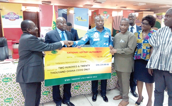 Torgbui Nyonyo (3rd left), the Board Chairman of the NLA, presenting a cheque for GH¢220,000 to Capt. Dua (Retd), Executive Secretary of VAG. With them are Major General C.B Yaache (2nd left), Board Chairman of VAG, Mr Kofi Osei Ameyaw (3rd right) and some board members of the NLA