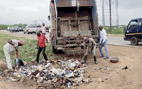 Members of the task force collecting refuse into a truck