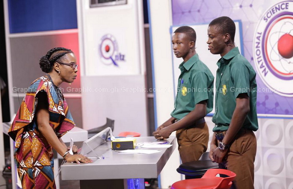 Dr Elsie Effah Kaufmann, curent quiz mistress examining a solution in one of the contests