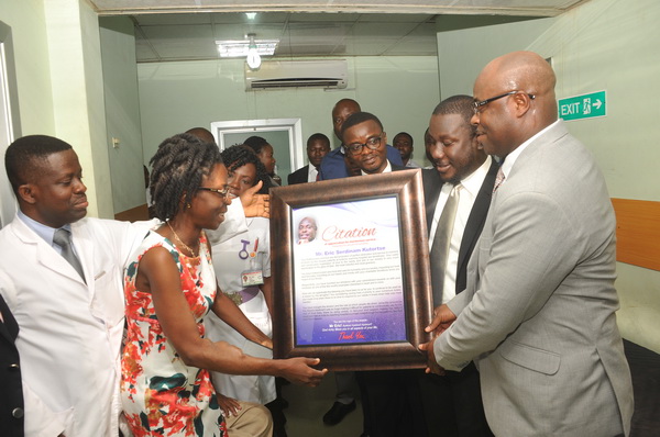 Mr Eric Seddy Kutortse (right) receiving a citation for his contribution towards the development of the ward from a patient. With them are Dr Vincent Boima (left), the Head of the unit, and some officials of the company.