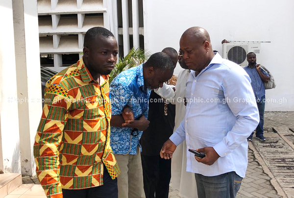 Obengfo in blue attire being assisted out of the courtroom