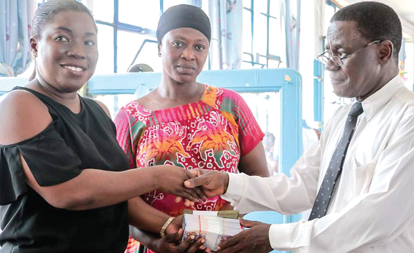 Ms Attakora-Manu (left) presenting the amount to Dr Emmanuel Adu while the mother of the patient looks on