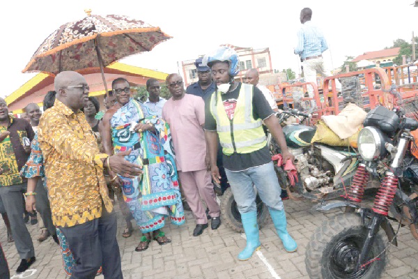 Mr Kofi Adda (left), the Minister for Sanitation, seeking some clarification from the Chairman of the Aboboyaa Association of the Oti Landfill site, Mr Salim Mohammed (right), after the unveiling of the branded tricycles. Those looking on include Mr Osei Assibey Antwi (2nd right), the Metropolitan Chief Executive for Kumasi, and the Asemhene, Nana Asare Kyei Baffour (in cloth).