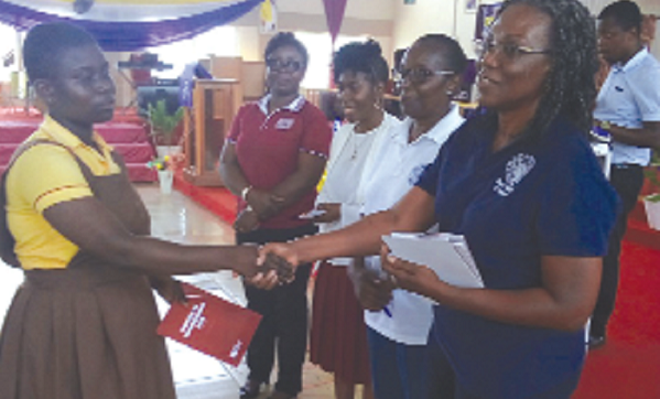  The first female graduate engineer, Ing. Mrs Sylvia Asare, presenting a booklet, with information on engineers in the country, to a representative of  one of the participating schools