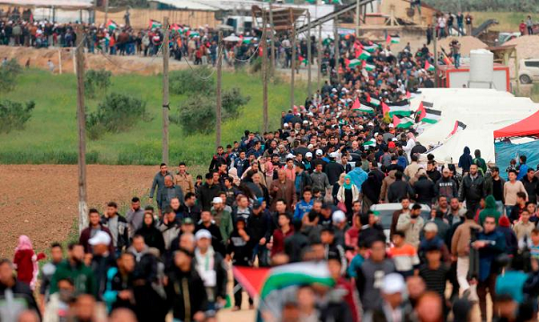 Palestinians march past a tent city erected along the border with Israel east of Gaza City on Friday.