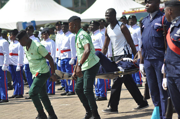 Some personnel of the Ghana Ambulance Service carrying an officer of the Ghana Police Service, who collapsed at the anniversary parade at the Jubilee Park in Kumasi. Picture: EMMANUEL BAAH
