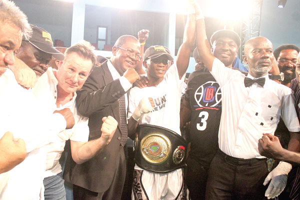 Referee Roger Barnor (right) lifts the hand of Oluwaseun as Peter Zwennes and Azumah Nelson(left) join in the celebration